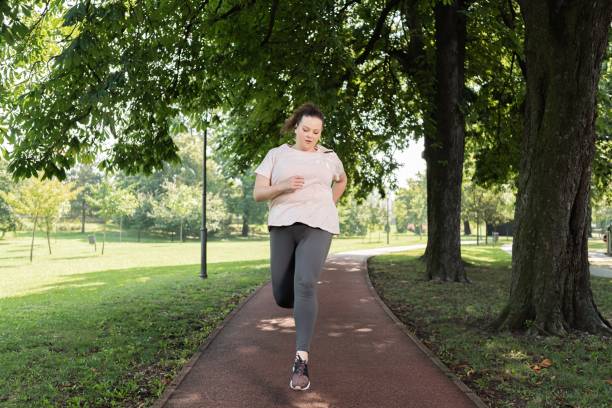 istock Fat woman jogging at park 1269208767