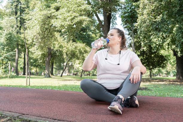 istock Plus size woman drinking water during outdoor workout 1269208787