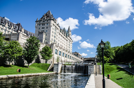 Lock of Rideau Canal in Ottawa during summer day\nChateau Laurier hotel in background