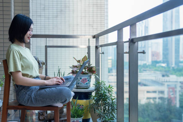 A freelancer works with a laptop on a balcony at home