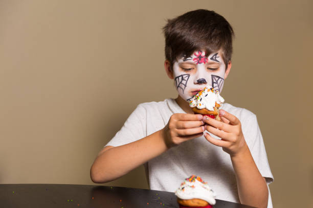 istock Boy eating spooky Halloween cupcakes 1269227406