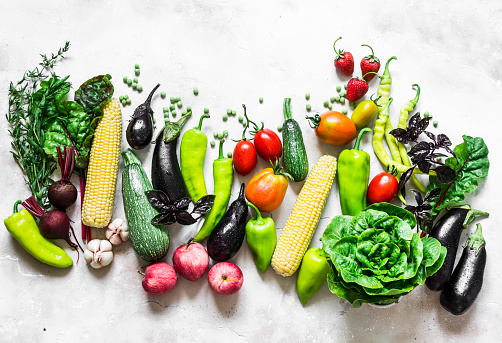 Summer harvest - fresh organic vegetables fruits background. Organic garden vegetables, berries, fruit on a light background, top view