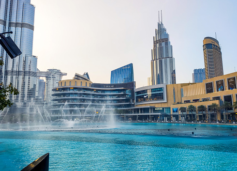 Dubai, United Arab Emirates - August 16, 2020: Dubai mall fountain in front of the mall at sunset. Largest shopping mall by area and one of the main attractions in Dubai, UAE reopens after coronavirus Covid 19 pandemic