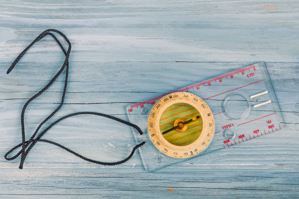 istock Transparent plastic compass on wooden background 1269245372