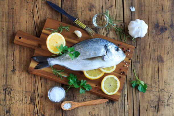 istock Raw sea bream on wooden board with ingredients 1269245667