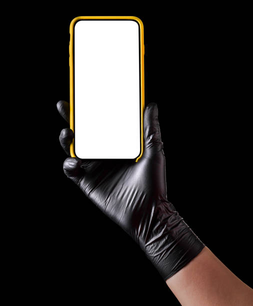 istock Hand in black glove holding mobile phone with blank screen isolated on black 1269247550
