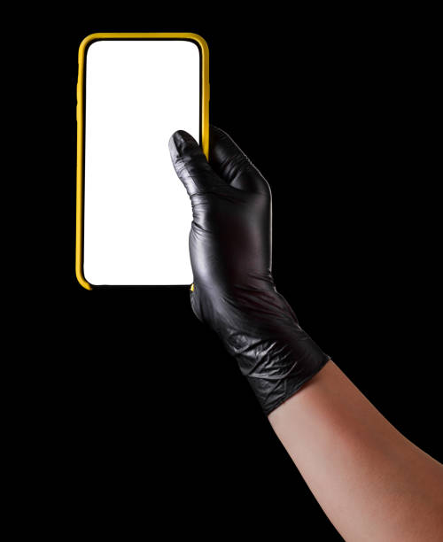 istock Hand in black glove holding mobile phone with blank screen isolated on black 1269247573