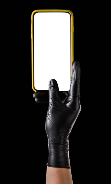 istock Hand in black glove holding mobile phone with blank screen isolated on black 1269247683