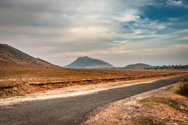 countryside empty rural road with mist and surrounded by mountains at morning image is taken at dashrath manjhi path gaya bihar India. It is showing the serene less populated beauty of bihar.
