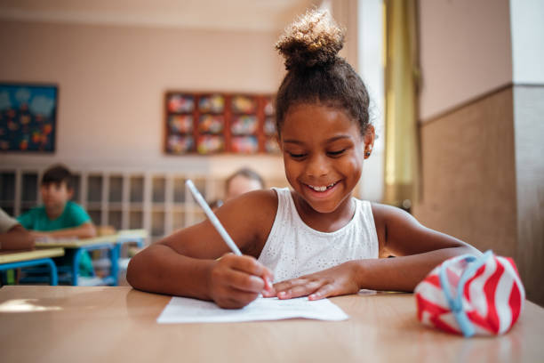 écolière de sourire prend un test - schoolgirl little girls crayon human face photos et images de collection