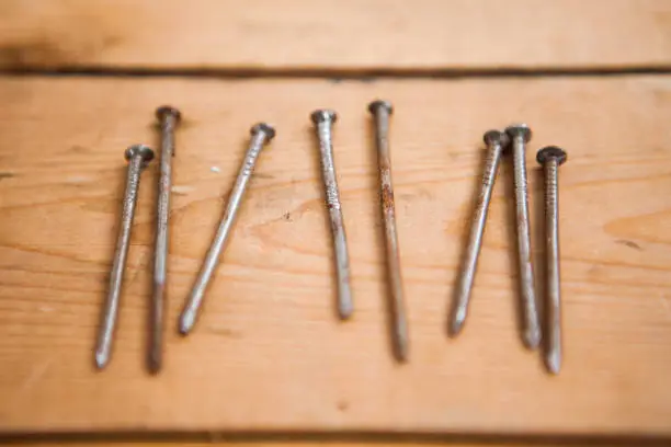 Photo of Set of metalware, rusty nails on the wooden background