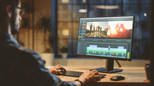 istock Over th Shoulder Shot: Young Professional Videographer Works on Desktop Computer, Doing Footage Montage, Using Video Editing Software. Modern Video Developers Office in the Evening 1269257052