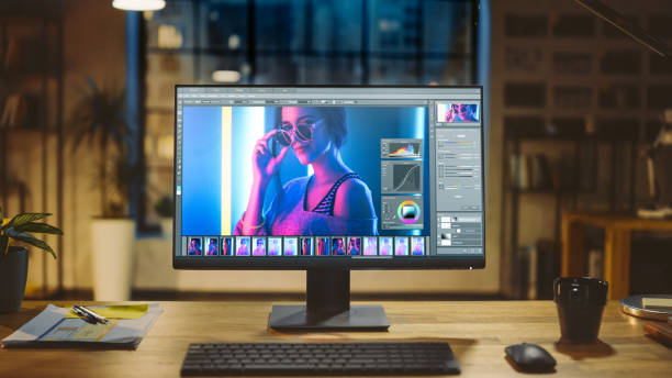 Shot of a Desktop Computer in the Modern Office with Monitor Showing Photo Editing Software. In the Background Warm Evening Lighting and Open Space Studio with City Window View Shot of a Desktop Computer in the Modern Office with Monitor Showing Photo Editing Software. In the Background Warm Evening Lighting and Open Space Studio with City Window View retouching stock pictures, royalty-free photos & images