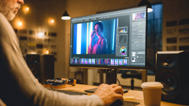 istock Creative Middle Aged Digital Editor Works in Picture Editing Software on His Personal Computer with Big Display. Stylish Modern Studio Office in the Evening. 1269257160