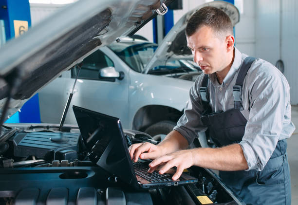 istock car mechanic using a computer laptop to diagnosing and checking up on car engines parts for fixing and repair. 1269258603