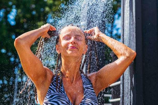 istock Shower. The woman is taking a shower outside. 1269260001