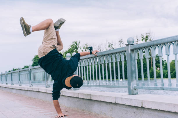 istock B-boy Break Dancer stands on one arm with an action camera. 1269262690