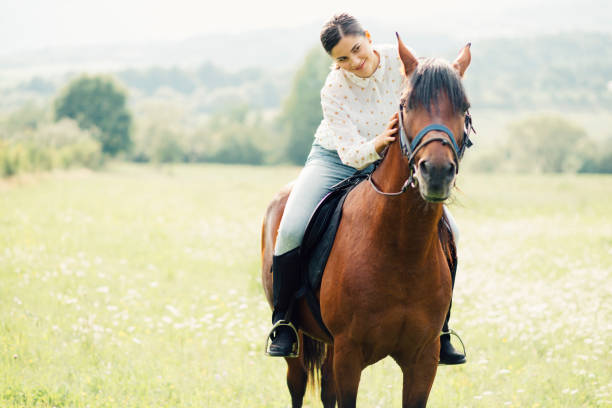 istock Young women rides a horse 1269264268