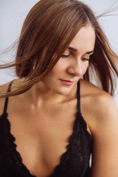 istock Young attractive girl in a black top on a light background 1269266139