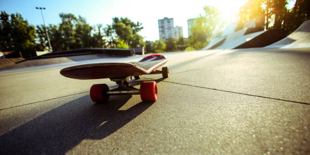 Low angle view of a skate park during sunset, focus on the skateboard.