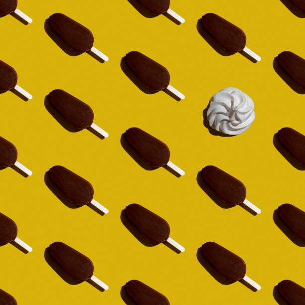 istock Seamless pattern colorful chocolate ice cream popsicle and one marshmallow on a yellow background top view, flat lay 1269269395