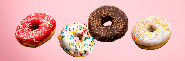 istock Donuts flying in the air on a pink background. Bakery, baking concept. Levitation. Banner 1269269930