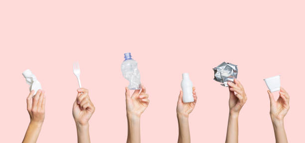 istock Hands hold trash on a light pink background. The concept of separate trash, stop plastic, recycling 1269270322