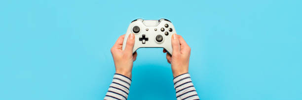 istock Hands holding a gamepad on a blue background. Banner. Concept games, video games 1269271121