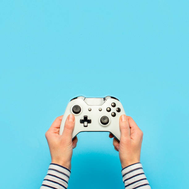 istock Hands holding a gamepad on a blue background. Banner. Concept games, video games 1269271483