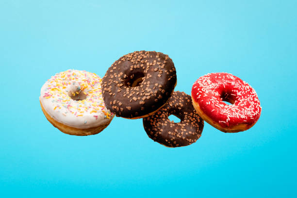 istock Donuts flying in the air on a blue background. Bakery, baking concept. Levitation 1269271897
