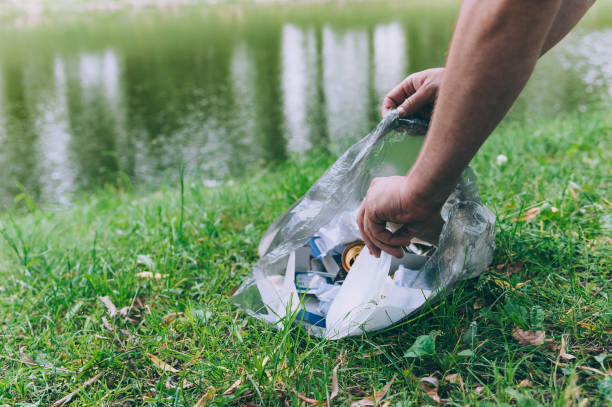 istock Guy picks up trash from nature in a waste bag. 1269273198