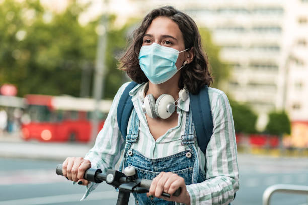 istock Woman with mask driving electric scooter 1269273312
