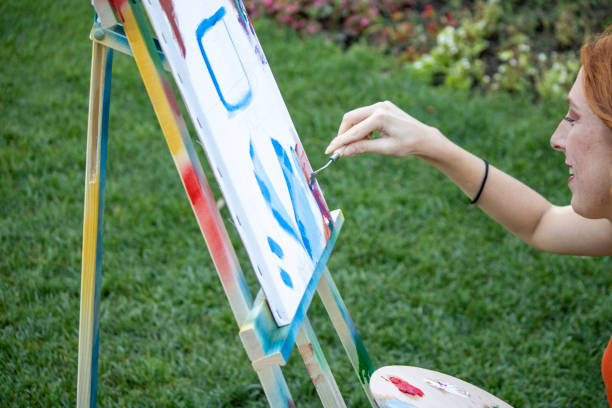 istock girl painter paints in the garden 1269273382