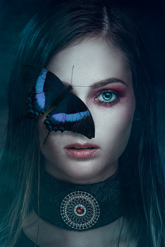 Portrait of beautiful woman with butterfly on her face