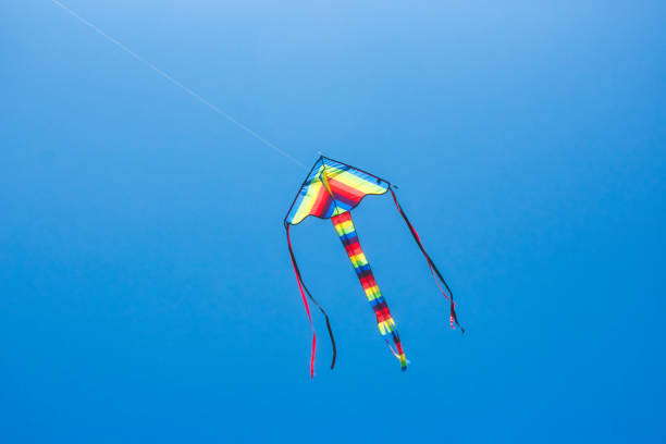 istock A colourful kite flying in a clear blue sky with a long tail and streamers 1269277897