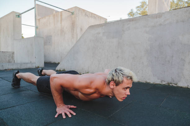 istock Young athletic man doing push ups on parkour area. Training alone outdoors. 1269278716