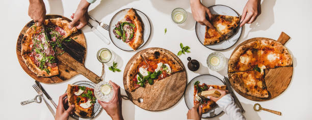 istock Flat-lay of various pizzas, drinks and peoples hands eating pizza 1269278832