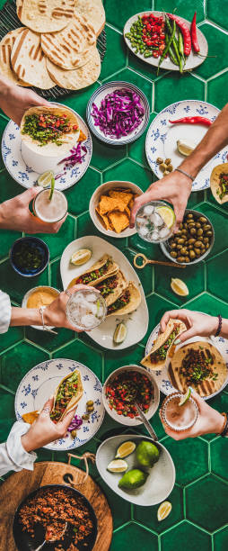 istock Peoples hands with drinks over mexican taco party table 1269278844