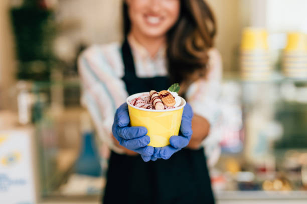 istock Happy brunette worker in ice cream store 1269282877