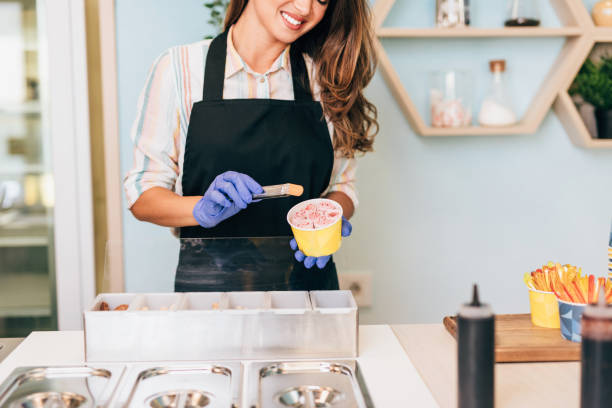istock Happy brunette worker in ice cream store 1269282895