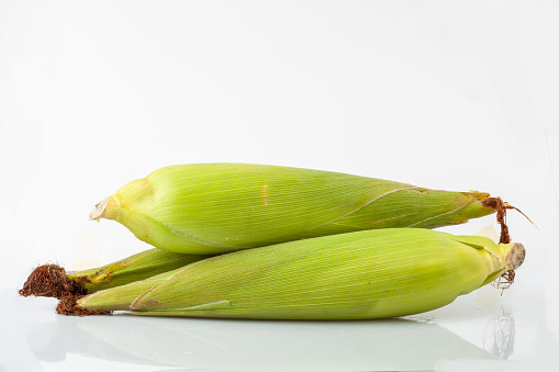 green fresh corn on white background