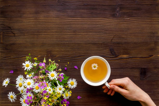 istock Wild flowers bouquet with cup tea on a table, top view 1269291464