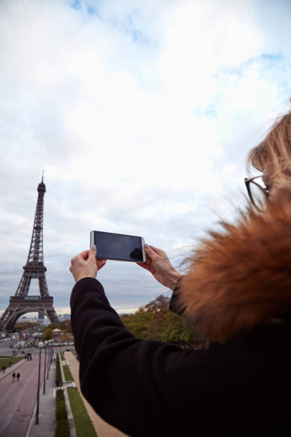 istock Girl using cellphone with Paris city background and Eiffel tower. 1269291621