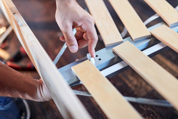 istock Carpenter hobbyist assembling wooden boards at home / garage. 1269291713
