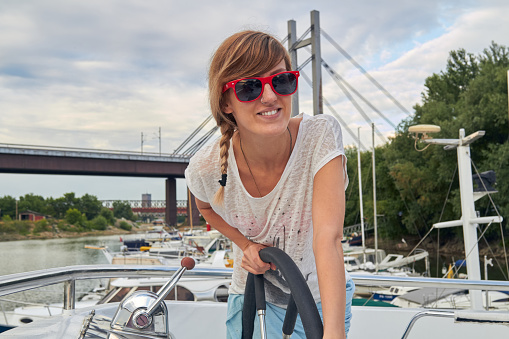 Young caucasian woman sailor enjoying summertime.