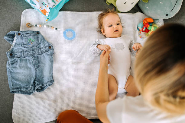 istock Young single mother dressing up her little cute baby boy 1269293377