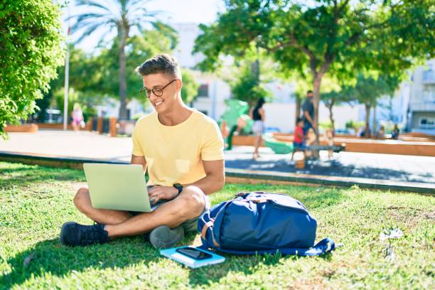 junge hispanische studentin lächelnd glücklich mit laptop sitzen deiner wiese auf dem universitätscampus - nerd computer learning fun stock-fotos und bilder