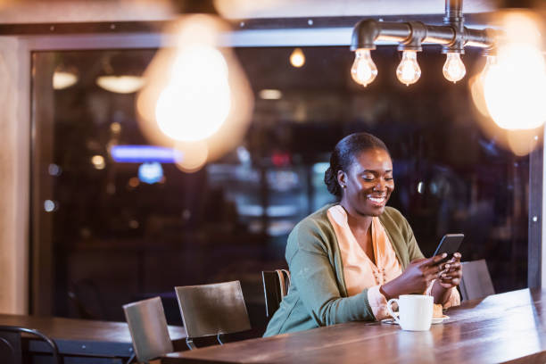 istock African-America woman having coffee, using smart phone 1269306291
