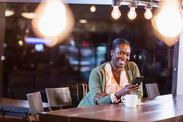 istock African-America woman having coffee, using smart phone 1269306354