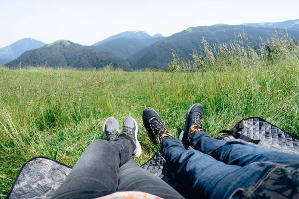 istock Low Section Of Couple Relaxing On Grass Against Mountains 1269306694